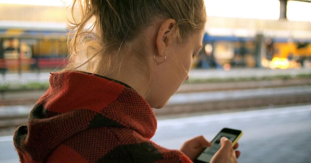 Підліток зі смартфоном уночі на тлі цифрового простору — ілюстрація до нічних обмежень соцмереж у Британії