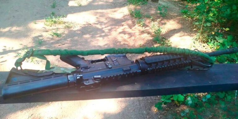 Дві одиниці вилученої стрілецької зброї поряд із військовою формою